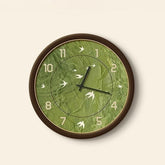 Green wall clock with leaf pattern on a beige background