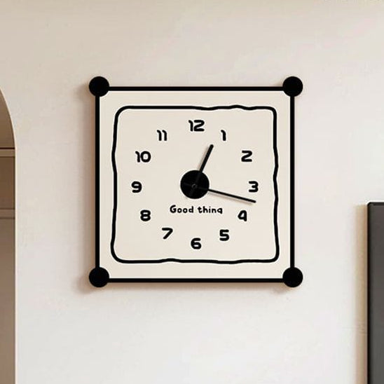 Square wall clock with black frame and white face on a wall in a room.
