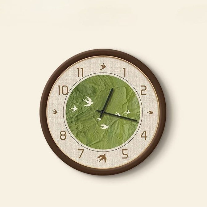 Wall clock with green leaf design and brown frame on a beige background
